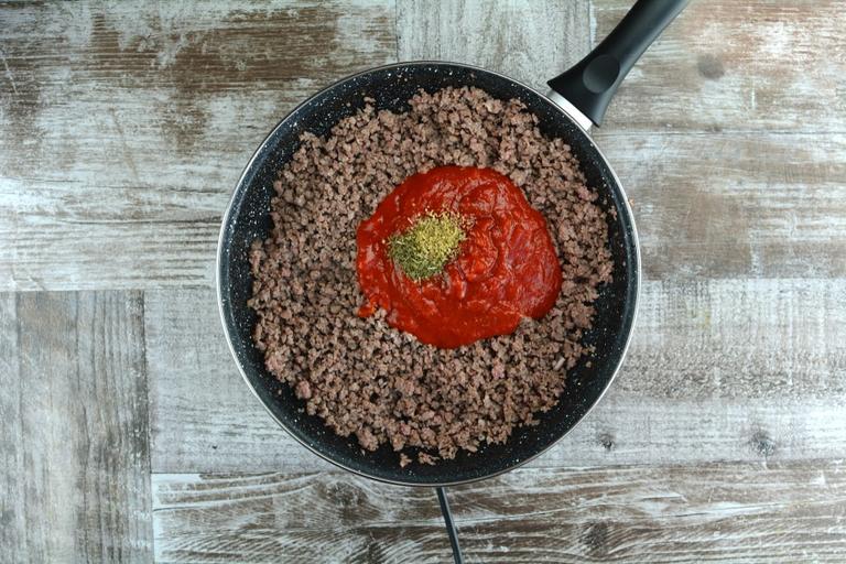 When beef is almost well-done add tomato pasta and spices.